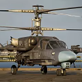 Military Helicopter With Rotors Mounted Weapons Gray Fuselage And Light Blue Nose On Ground