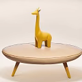 Yellow Wooden Giraffe Doll Placed On Round Beige Table With Thin Legs