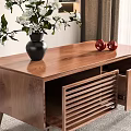 Wooden Coffee Table With Black Vase White Flowers Two Red Apples And Louvered Drawer