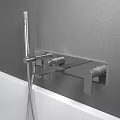 Wall Mounted Bathroom Faucet with Handheld Shower Above White Bathtub on Gray Wall