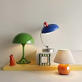 Stylish Table Lamps in Green Blue and Orange on Yellow Shelf with Small Red Decor