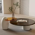 Modern Living Room Coffee Table With Round Dark Top White Base Open Magazine And Plant Vase