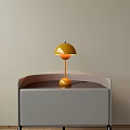 Yellow Mushroom Shaped Table Lamp With Round Base On Gray Cabinet And Light Wall Background