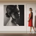 Black and White Portrait Painting on Wall with Blurred Figure in Red Dress Walking Nearby