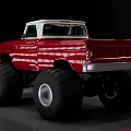Red Vintage Modified Truck With Large Monster Tires And White Roof