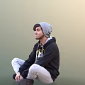 Man Sitting On The Ground Wearing Black Hoodie With Design Gray Beanie And White Pants