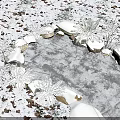 Frozen Water Fountain Surrounded by Snow Covered Stones Ferns and Fallen Leaves