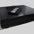 Modern Black Entertainment Media Player With Remote Control And Cassette Tape On Top
