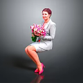 Woman in gray suit holding pink white bouquet wearing pink high heels against gray background