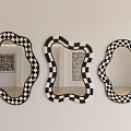 Three Stylish Mirrors With Black And White Checkered Frames And Irregular Shapes On Wall