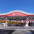 Red and White Canopy Gas Station with Fuel Pumps and Trees Around Vehicles Refueling