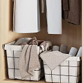 Neatly Arranged Wooden Wardrobe With Hanging Colorful Robes And Folded Towels