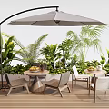 Outdoor Table With Parasol And Chairs On Wooden Deck Surrounded By Green Plants