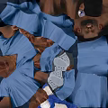 Man In Blue Scrubs Standing Full Body Against Light Colored Backdrop