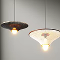 Two Modern Illuminated Pendant Lights With Perforated Shades Hanging In Light Gray Room