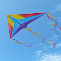 Colorful Triangular Kite Flying High in Blue Sky with Long Colorful Streamers