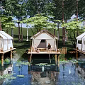 Lakeside Glamping Site with Overwater Platforms White Tents and Wooded Surroundings