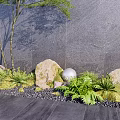 Courtyard Garden Design With Gray Wall Green Plants Rocks And Spherical Decorations