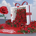 Illuminated Floral Installation With White Gift Box Red Ribbon Bow And Abundant Red Roses