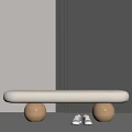 Light Gray Padded Bench with Two Round Wooden Legs and White Shoes Near Gray Wall