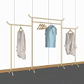 Golden Metal Clothes Rack With White Shirt Light Blue T shirt And Light Coat Hanging