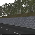 Roadside Stone Wall With Grass And Flowers On Top Surrounded By Trees