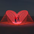 Heart Shaped Red Photo Spot With Two People Standing Inside Illuminated Structure