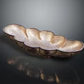Golden Petal Shaped Decorative Metal Tray With Shiny Surface And Reflection On Black Background