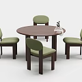 Round Wooden Dining Table With Four Green Cushioned Chairs And Glass Vase Plant