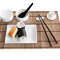Sushi Rolls On White Plate With Bamboo Mat Chopsticks And Small Bowls