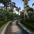 Curved Stone Path Road Facilities With Green Bushes Palm Trees And White Buildings Blue Sky