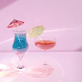 Two Decorative Wine Glasses With Blue Red Drinks And Umbrella On Pink Background Soft Light