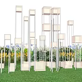 Outdoor Art Installation With Vertical Square Structures Person Grass Purple Flowers Trees Evening Sky