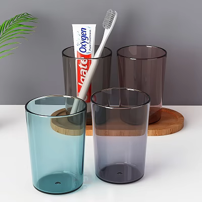 Daily Washing Essentials With Colorful Glass Cups Toothpaste Toothbrush And Green Leaves On Wooden Tray 3d model