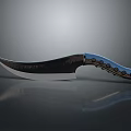 Curved Blade Knife With Blue Black Handle And Decorative Patterns On Dark Surface