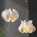 Modern White Wavy Pendant Light With Warm Glow Against Gray Wall And Green Plant