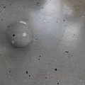 Gray Glossy Floor Tiles With Black And White Specks And Sphere Decoration