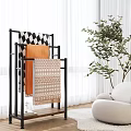 Modern Living Room With Black Metal Rack Displaying Colorful Patterned Throw Blankets And Green Plant