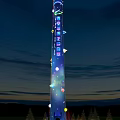 Tall Illuminated Landscape Column Against Evening Sky With Colorful Lights And Ornaments