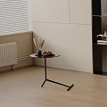 Modern Round Side Table with Black Metal Legs and Decorative Fruits in Living Corner