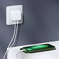 White USB Phone Charger Plugged in Wall Socket Charging Green Mobile Phone