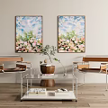 Modern Living Room With Floral Paintings Two Chairs Glass Coffee Table Vase And Books