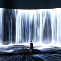 Person Sitting on Chair Facing Giant Flowing Water Curtain with Flowing Light on Ground