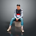 A Man Sitting On Cylindrical Stool Wearing Black Cap Gray Jacket And Blue Jeans