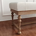White Tufted Bench with Wooden Legs in Room with White Paneled Walls and Green Plant