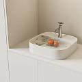 Modern White Washbasin With Square Basin Faucet Running Water Oranges On White Countertop