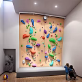 Indoor Rock Climbing Wall With Colorful Holds and People Watching in Modern Room