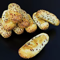 Golden Brown Bread Sticks Topped With Sesame Seeds Arranged In A Stack On Black Background
