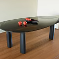 Modern Black Oval Dining Table with Red Fruits and Black Bowl on Wooden Floor