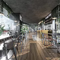 Modern Restaurant Outdoor Dining Space With Warm Lighting Green Plants And Cobblestone Pavement